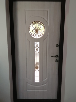 Дверь с ковкой и стеклом в частном доме, вид изнутри